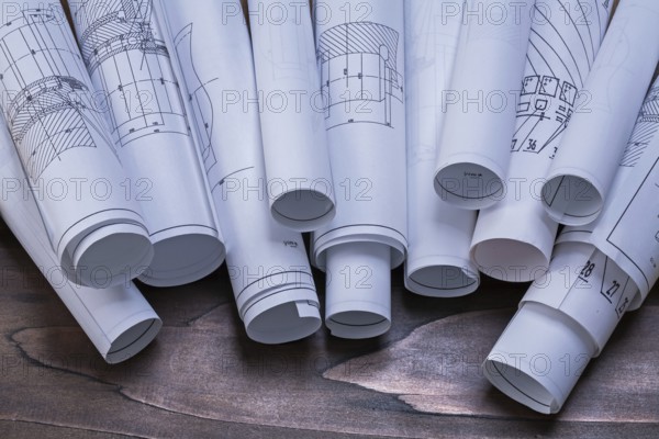 Rolls of construction plans on pine wooden vintage board maintenance concept