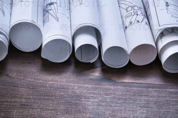 Pine wooden vintage board with stack of blueprint rolls construction concept