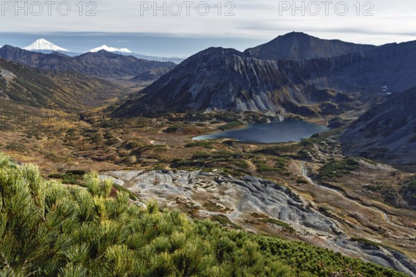 Beautiful autumn mountain landscape: picturesque view of mountains, lake and volcanoes. Far East, Russia, Kamchatka Peninsula, Europe