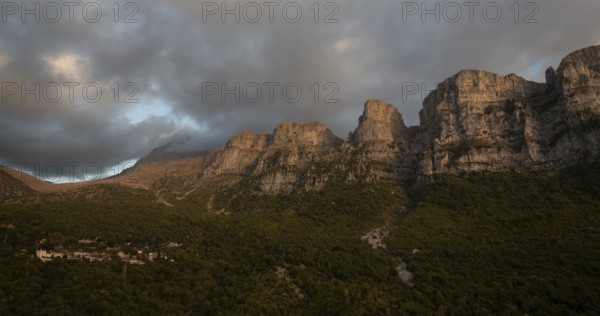 Drone scenery mikro Papingo village, Zagorochoria area, Epirus, Ioannina Greece. Astraka tower rocky cliffs above the village at sunset