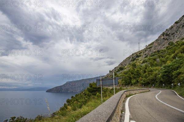 Coastal landscape shot. View from a road leading along the sea and through a breathtaking green Mediterranean landscape. Coast near Salerno, Italy, Europe