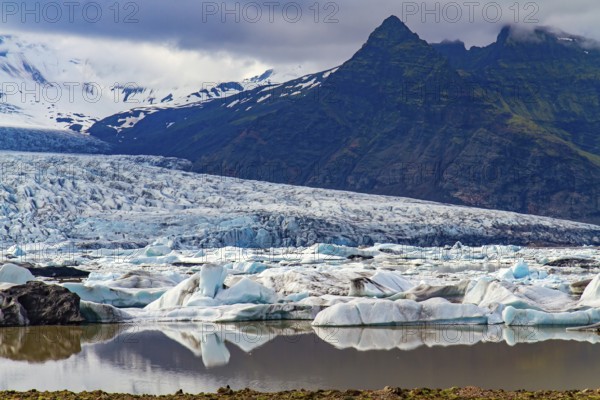 Cold summer in the Arctic. Jokulsarlon glacial lagoon. The imposing scenic lagoon in the north of Iceland. Glaciers and icebergs among cold mountains. Iceland