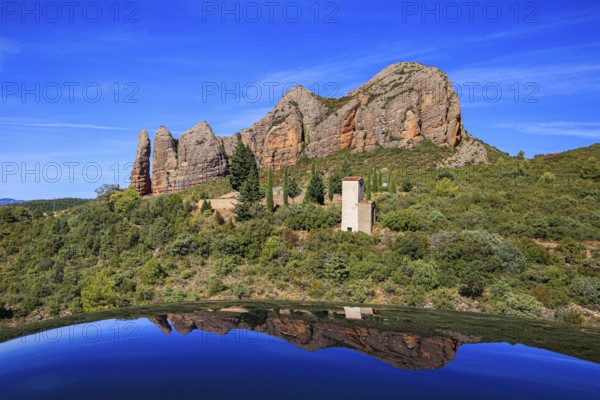 The rocks are beautifully reflected in the shiny surface of the car. Aguero village at the foot of the dangerous Mallos cliffs. The magical nature of Spain. Province of Huesca, Aragon