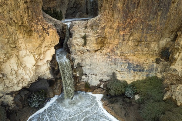 Powerful waterfall in the Judean Desert around the Dead Sea after heavy winter rains. Israel. Abstract image of a real event. Original unexpected angle. Shooting from a drone