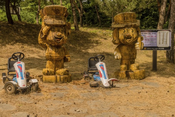 Geosan, South Korea, August 26, 2020: Carved wood statues of Korean police officers in mountain recreational forest on sunny day, Asia