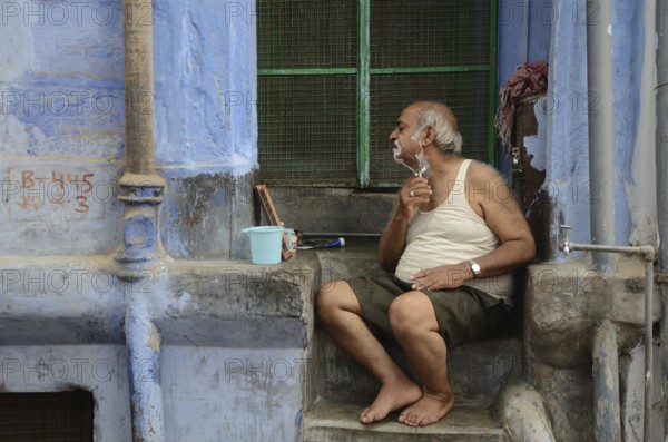 Old man shaving in front of house, jodhpur, rajasthan, India, Asia