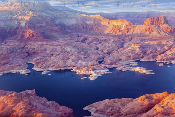 U.S. The coast of Lake Powell is cut by narrow canyons. Grandiose huge lake of artificial origin among the picturesque red sandstone cliffs. Landscape under the wing of an airplane