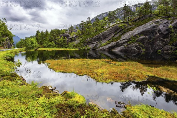 Scenic landscape in Western Norway. The picturesque road in Norway. Summer cold and rainy day. Quiet lake next road to Roldal. The trip to the north of Europe