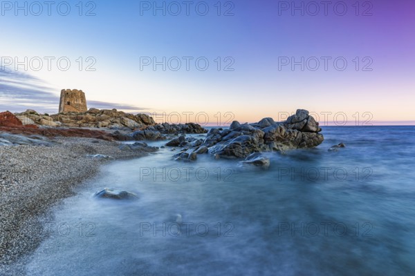 Old historic tower from the 16th century and rocks at sunset on the beach, long exposure, Torre di Bari, Barisardo, Ogliastra, Sardinia, Italy, Europe