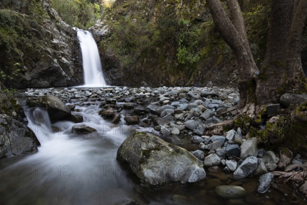 Beautiful Waterfall with stones on the ground in the heart of Machairas forest at Troodos mountains in Cyprus