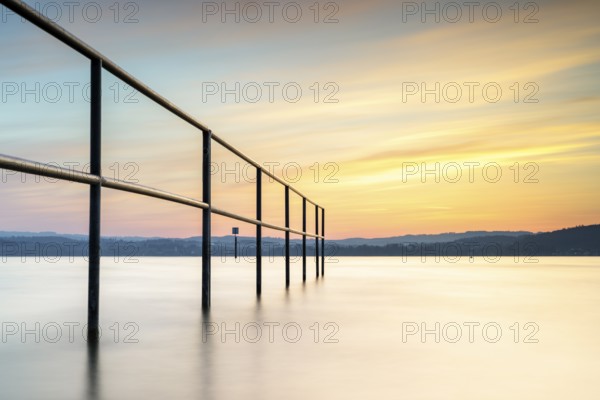 Railing in the lake in the warm light of the sunset, quiet atmosphere, lido, Litzelstetten, Lake Constance, Baden-Württemberg, Germany, Europe