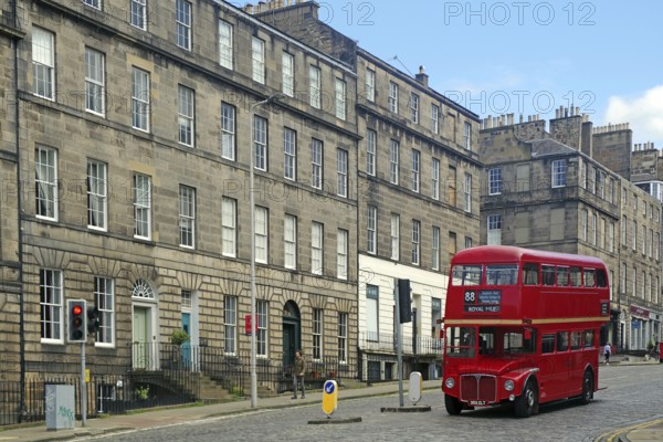 Red double-decker bus in historic old town with classic buildings and blue sky, Capital City, Edinburgh, Scotland, United Kingdom, Europe