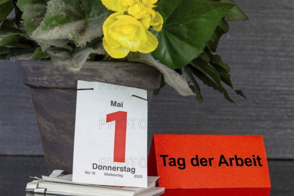 May Day: The page of a tear-off calendar shows the date 1 May, next to it a piece of paper with the added text DAY OF WORK