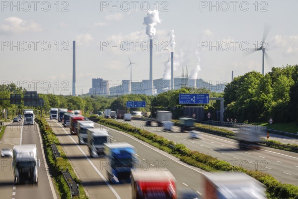 Many lorries driving on the A2 motorway, in the background the Uniper coal-fired power plant Gelsenkirchen Scholven, on the right a wind turbine, Industry and traffic in the Ruhr area, Bottrop, Ruhr area, North Rhine-Westphalia, Germany, Europe