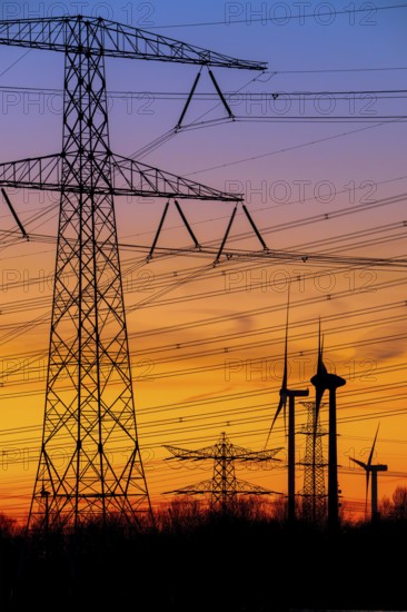 High-voltage electricity pylons, transmission towers and wind turbines at sunset near the Borssele Nuclear Power Station, Zeeland, Netherlands