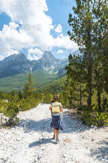 Woman hikers walking on Valbona Valley trail next to trees, Theth National Park, Albanian Alps, Albania, Europe
