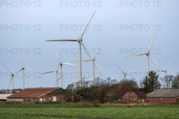 Norden, Lower Saxony, Germany - Wind turbines, wind farm near Norden in East Frisia. In front a farm with residential house