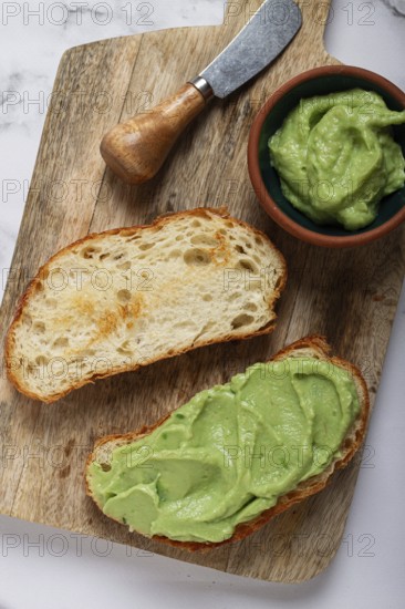 Ciabatta with avocado pasta, breakfast, on a chopping board, top view, homemade, no people