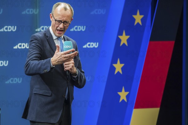 Election event of the CDU party for the Bundestag elections with top candidate Friedrich Merz. Portrait in front of the German flag and the flag of the European Union. Singen am Hohentwiehl. Baden-Württemberg, Germany, Europe