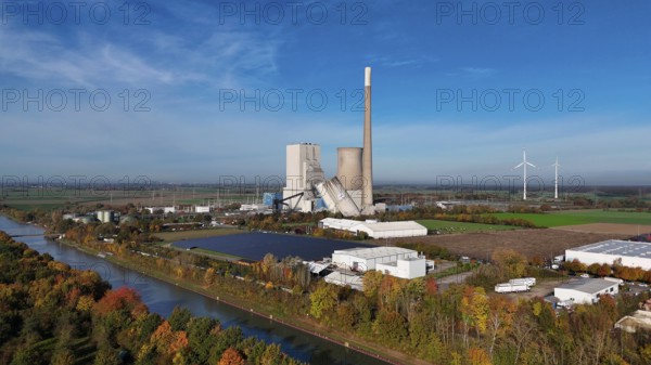Industrial landscape with power plant and wind turbines, surrounded by autumn trees along a canal, blasting of the ash silos, Mehrum coal-fired power plant, Peine district, Lower Saxony, Germany, Europe