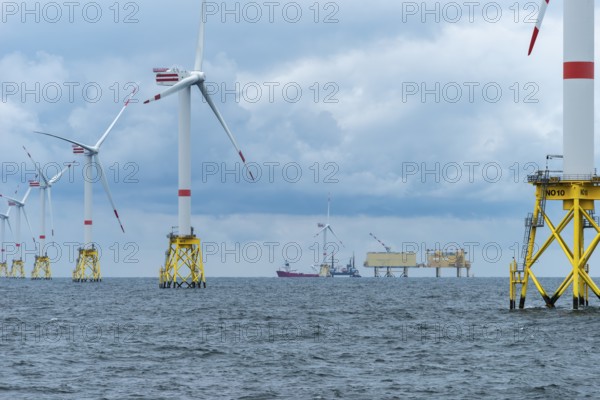 Offshore wind farm Nordsee Ost, operator RWE, north of Helgoland, German economic zone, wind turbines with jacket foundation structure, low swell, supply station, ship tug, Germany, Europe