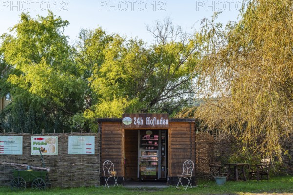Wooden hut with a vending machine for sausage and cheese in a 24-hour farm shop, village of Rieben near Beelitz, Fläming, Brandenburg, Germany, Europe