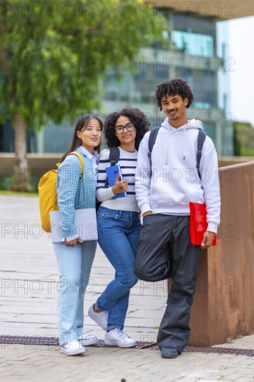 Vertical portrait of three multiracial university exchange students standing in the campus