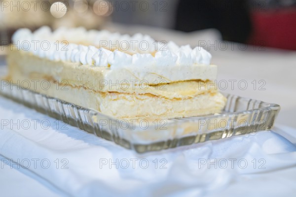 A creamy layer cake on a glass dish, placed on a white table, Europäischer Hof, Königsbach Stein, Germany, Europe