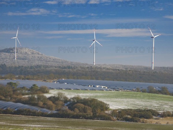 Solar park and wind farm near Breuna, with hoarfrost covered woodland in the background, North Hesse, Germany, Europe