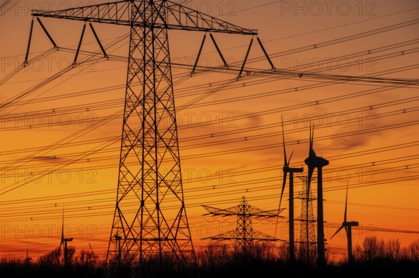 High-voltage electricity pylons, transmission towers and wind turbines at sunset near the Borssele Nuclear Power Station, Zeeland, Netherlands