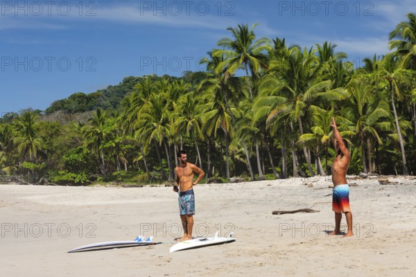 Surfers warming up on the beach of Santa Teresa, Nicoya Peninsula, Guanacaste, Costa Rica, Central America