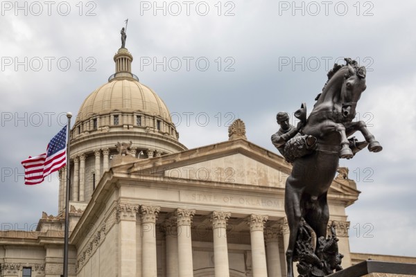 Oklahoma City, Oklahoma, The Oklahoma state capitol building. A sculpture by Constance Whitney Warren, labeled a 'bronze tribute to the romantic riders of the range, ' stands outside the building