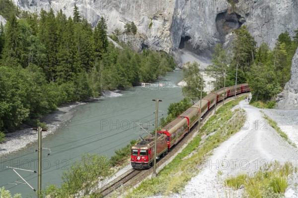 A Rhaetian Railway train travels through the Rhine Gorge, Ruinaulta, Anterior Rhine, Versam, Graubünden, Switzerland, Europe