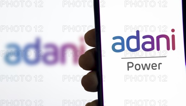 Adani Green Energy Limited on screen in front of business logo.