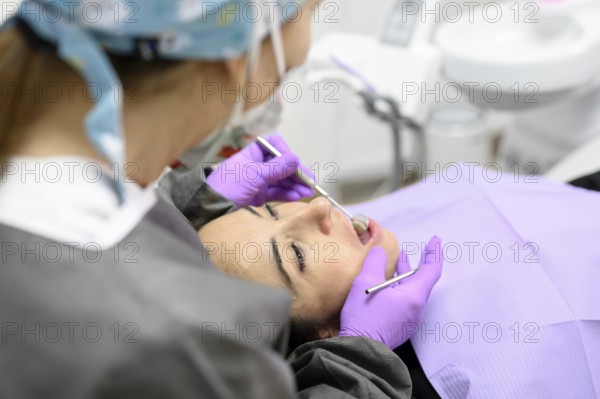 Dentist hygienist making oral hygienic cleaning in dentistry for young woman. Using professional electrical equipment dental drill machine to brush teeth in dentistry. High quality photo