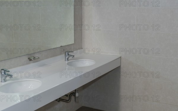 Closeup of double sink and mirror in public restroom in South Korea