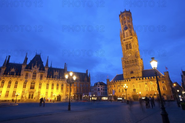 The provincial courthouse and belfry are illuminated at dusk in grote markt, the city center of Brugge, Belgium, Europe