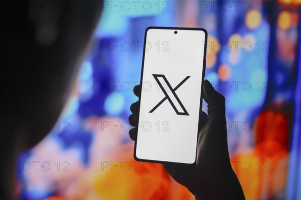 In this photo illustration, the X (Twitter) logo is displayed on a smartphone screen