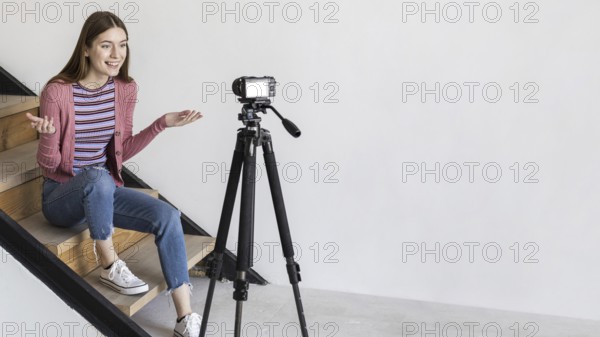 Blogger recording with camera sitting stairs. Resolution and high quality beautiful photo
