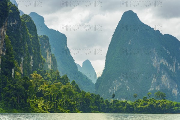 Misty mountain peaks covered in dense greenery under a cloudy sky, Cheow Lan Lake, Khao Sok National Park, Thailand, National Park, Khao Sok lake, water, mountains, green, Asia