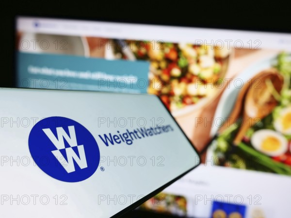 Stuttgart, Germany, 03-19-2023: Mobile phone with logo of WW International Inc. (Weight Watchers) on screen in front of business website. Focus on left of phone display, Europe
