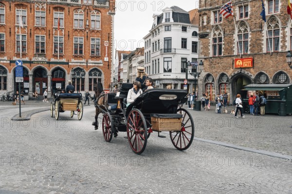 Bruges, Belgium, July 29, 2016: Horse carriage for tourists in Markt Square in the city of Bruges. The historic city centre is a World Heritage Site of UNESCO. It is known for his picturesque cobbled lanes and dreamy canals, Europe