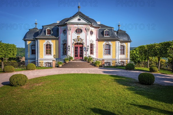 The rococo castle of the Dornburg Castles with manicured lawn and symmetrical trees against a clear blue sky, Dornburg-Camburg, Thuringia, Germany, Europe