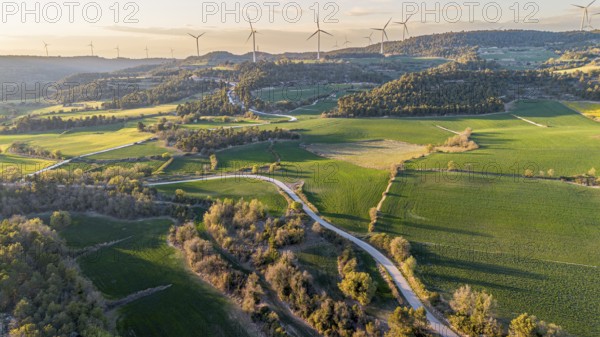 Aerial view of windmills on the hills between fields of cereal cultivation in the province of Tarragona in Catalonia in Spain