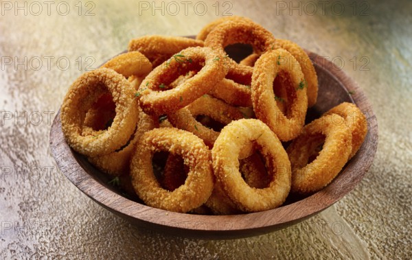 Deep fried onion rings, appetizer, with tomato sauce, on a wooden plate, without people, favorite dish