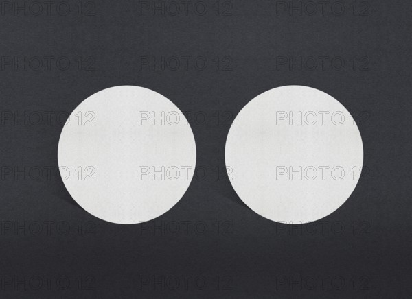 Two white circular papers symmetrically placed on a dark background, Blank white Business card mockup stacks at grey textured paper background