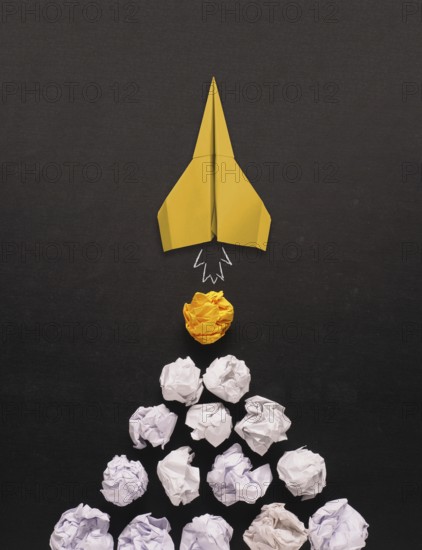 Launching paper rocket with jet stream of paper balls, creativity concept or new ideas metaphor, start up business, new year?s resolution