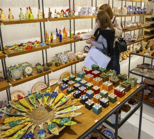 Shopping inside tourist souvenir craft shop selling pottery and ceramics, Guimaraes, northern Portugal