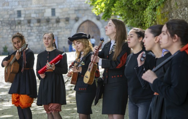 Group female university students musicians perform in street, city of Guimaraes, northern Portugal