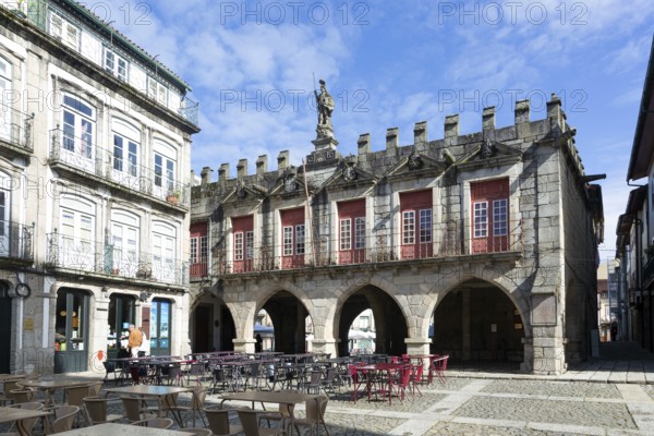 Tables and chairs, historic buildings in Largo da Oliveira square, city of Guimaraes, northern Portugal